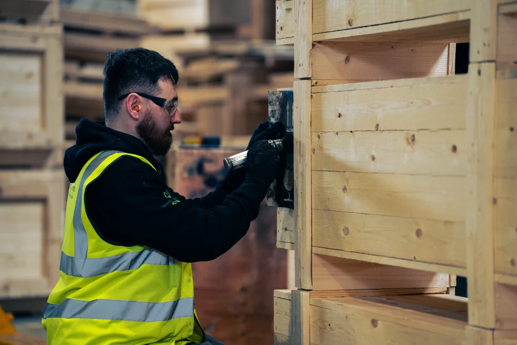 Operative working on a wooden export case in the warehouse