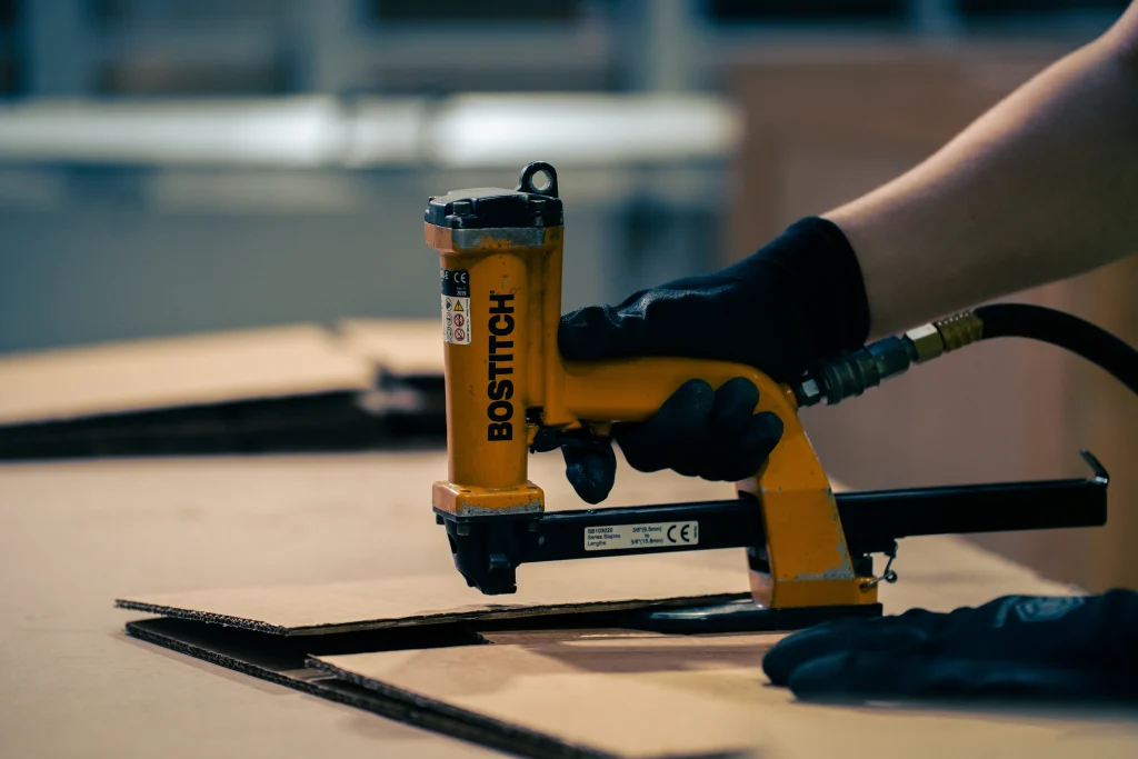 Handheld tool cutting cardboard sheets.