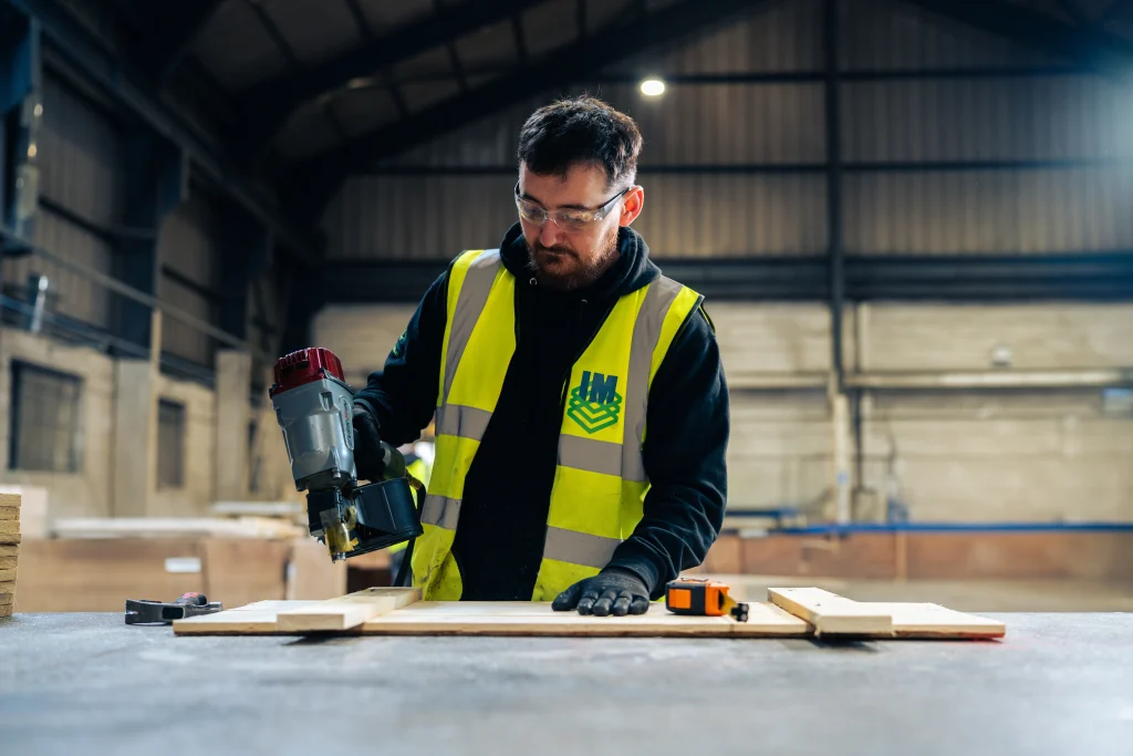 IM Export Services team cutting timber components for export packing