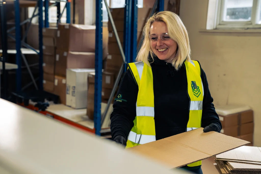IM Export Services team member preparing cardboard packaging in the warehouse.