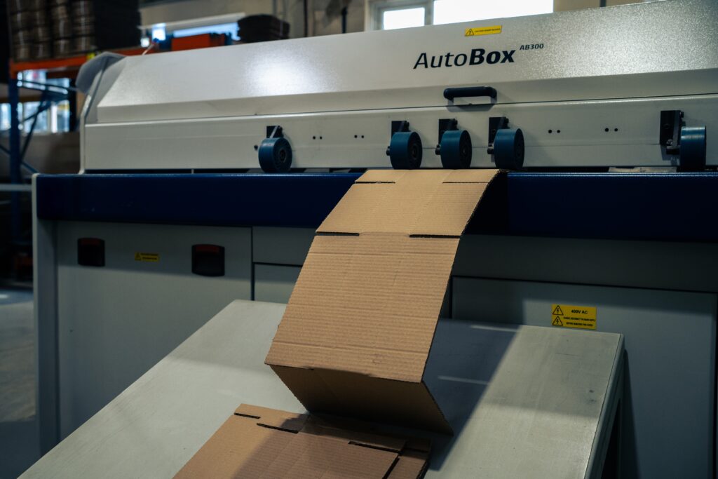 Cardboard being cut and processed on automated cutting machine for export packaging